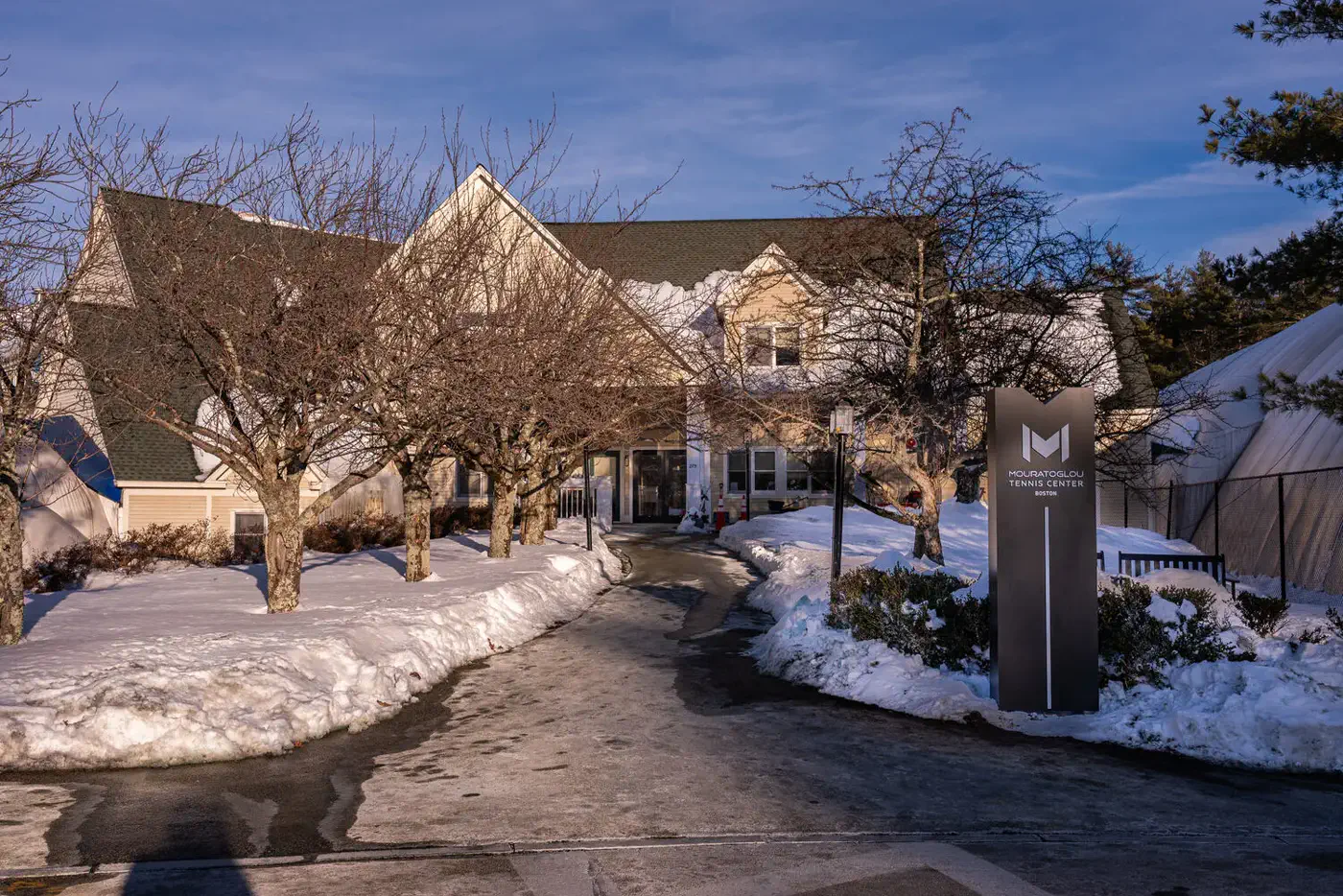 Ingresso del Mouratoglou Tennis Center Boston sotto la neve invernale a Concord, Massachusetts.