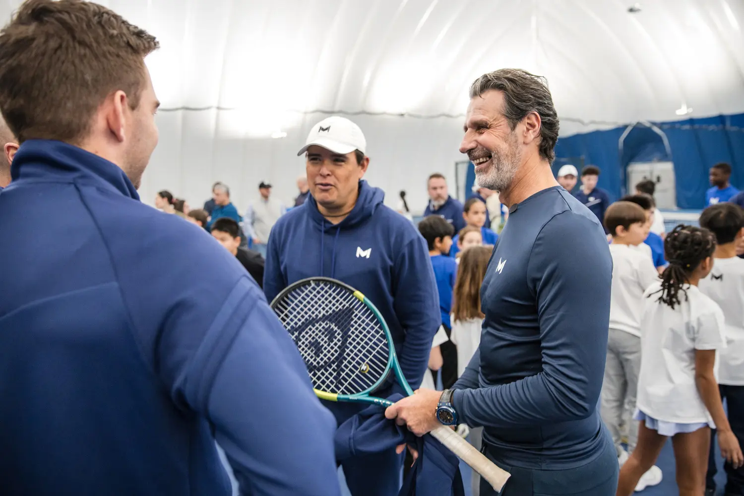 Patrick Mouratoglou échangeant avec des coachs au Mouratoglou Tennis Center Boston