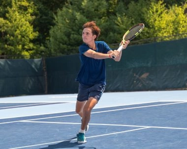 Giovane giocatore che colpisce un dritto su un campo all’aperto al Mouratoglou Tennis Center Boston, Massachusetts.