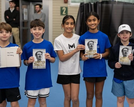 Giovani tennisti in posa con il libro di Patrick Mouratoglou al Mouratoglou Tennis Center Boston