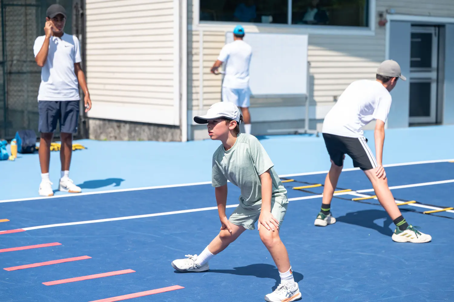 Jeunes joueurs travaillant leur jeu de jambes sur le court à Boston