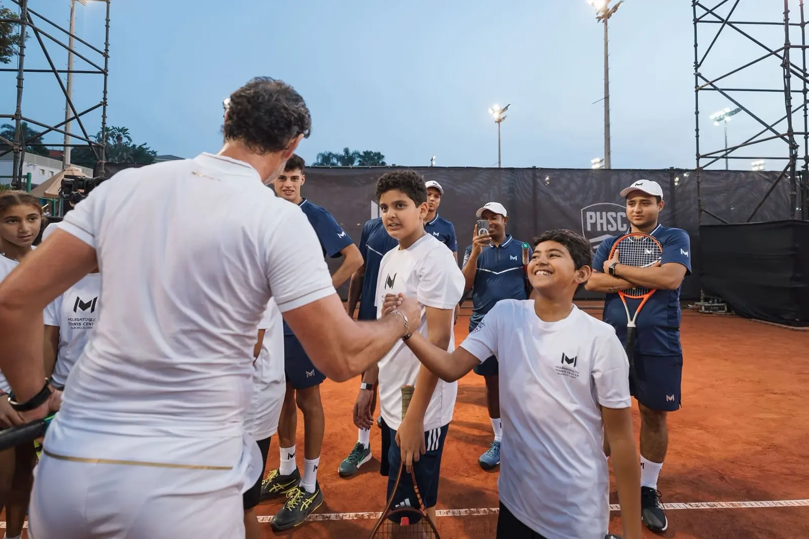 Patrick Mouratoglou saludando a un joven jugador durante un evento junior en el Mouratoglou Tennis Center Palm Hills