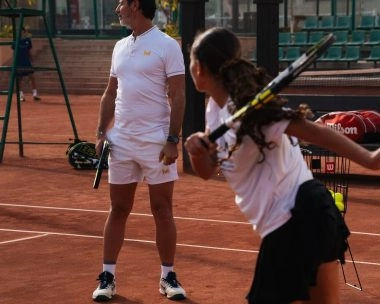 Patrick Mouratoglou observando a un jugador junior golpear una derecha en una pista de tierra batida del Mouratoglou Tennis Center Palm Hills Cairo.