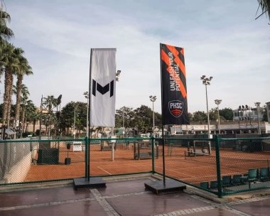 Banderolas de Mouratoglou y del Palm Hills Sporting Club junto a las pistas de tierra batida en El Cairo, Egipto.