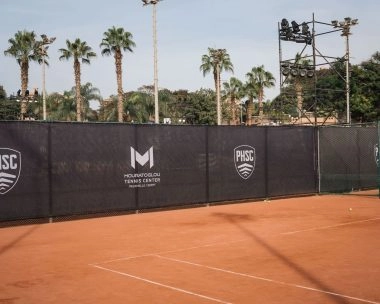 Pista de tierra batida y lonas cortavientos con la marca Mouratoglou en el Palm Hills Sporting Club, El Cairo.