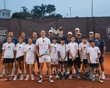 Patrick Mouratoglou posando para una foto de grupo con jugadores junior y entrenadores en una pista de tierra batida del Mouratoglou Tennis Center Palm Hills Cairo, en Egipto.