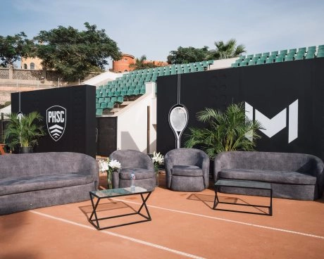 Escenario y zona de asientos preparados para un evento en una pista de tierra batida del Mouratoglou Tennis Center Palm Hills Cairo, en Egipto.