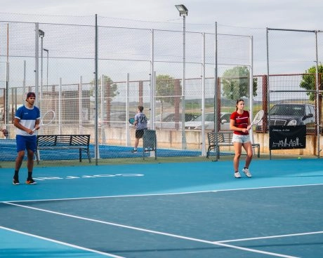 Zwei Tennisspieler auf den blauen Hartplätzen des Mouratoglou Tennis Center Calatrava beim Training oder beim Ausspielen eines Punktes