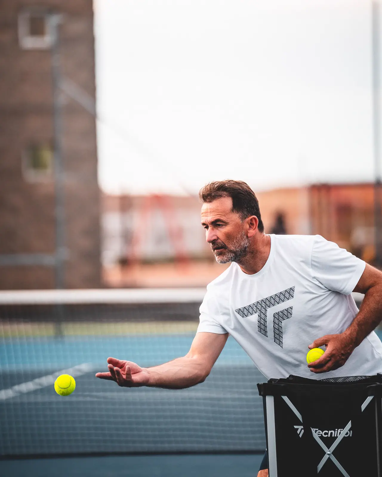 Coach feeding a ball during a lesson at Mouratoglou Tennis Center Calatrava