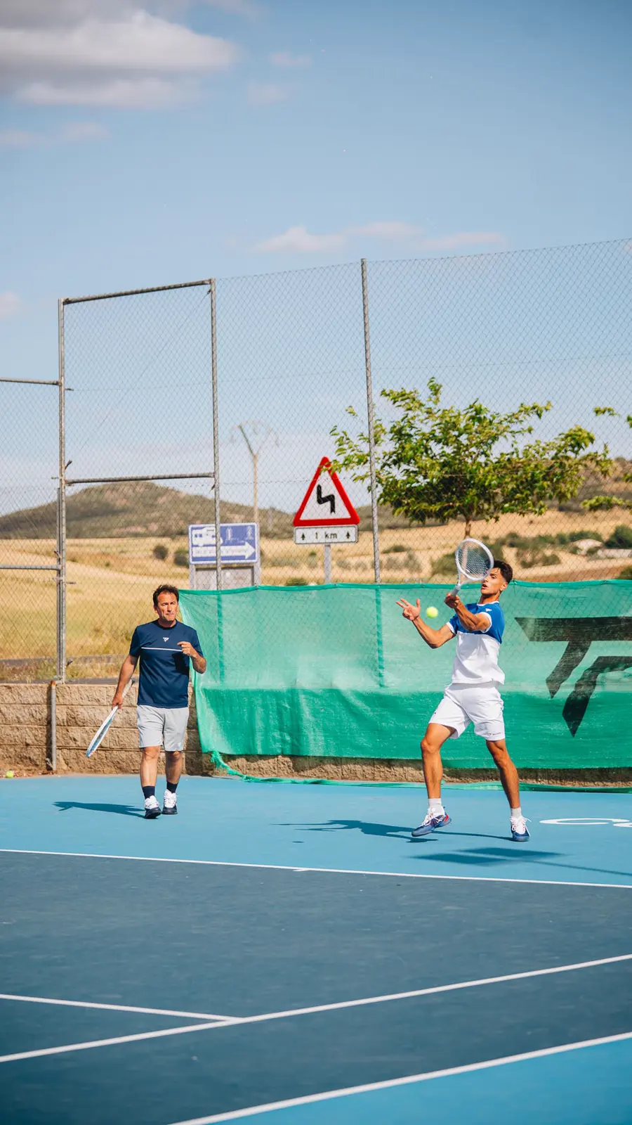 Young player hitting a forehand while a coach watches at Mouratoglou Tennis Center Calatrava