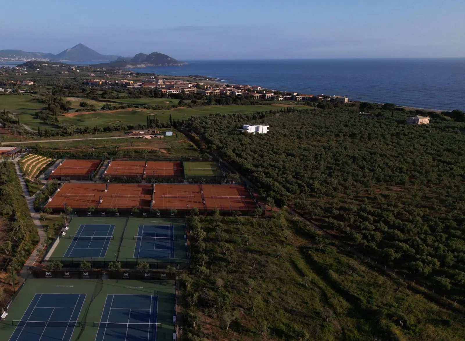 Vista aerea dei campi da tennis di Costa Navarino tra gli uliveti vicino alla costa.