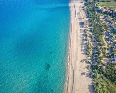 Vista aerea del mare turchese e della spiaggia di sabbia lungo la costa di Costa Navarino.
