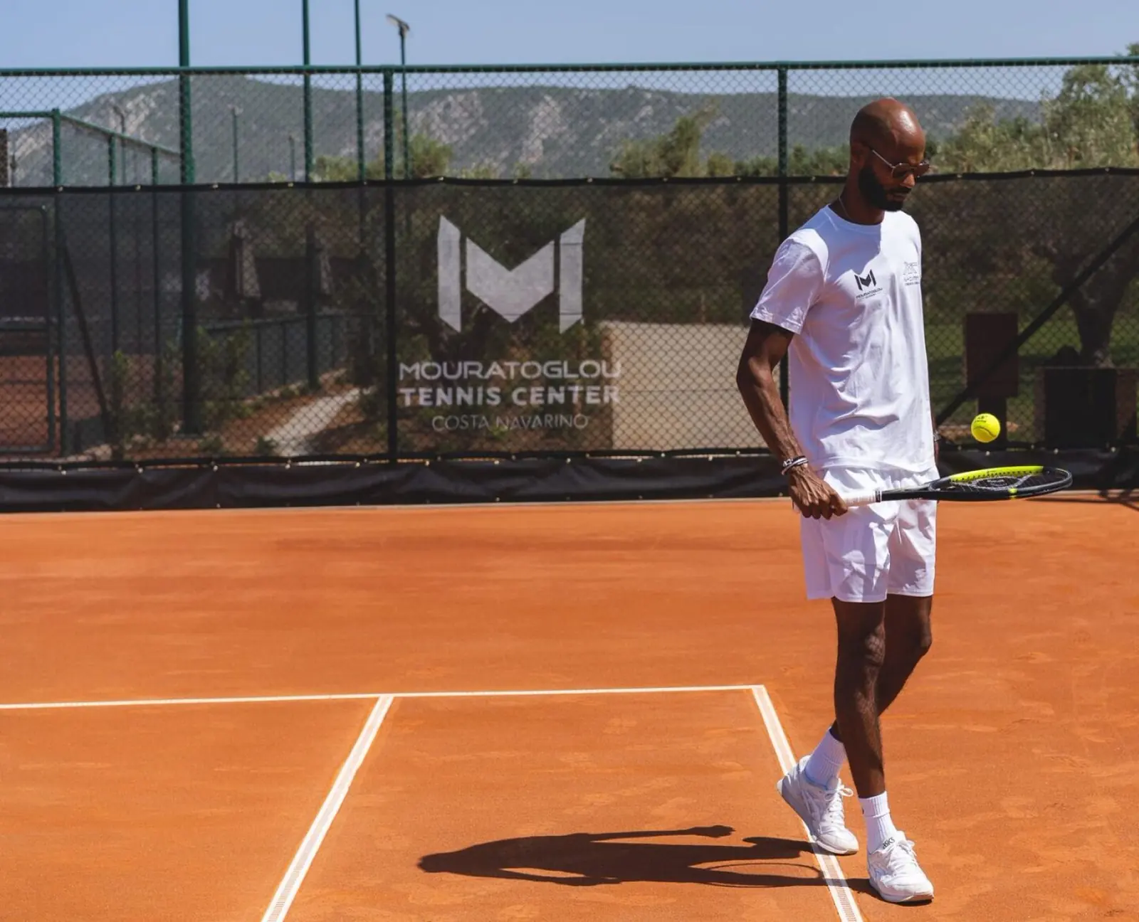 Entrenador Mouratoglou golpeando una derecha en una pista de tierra batida en Costa Navarino