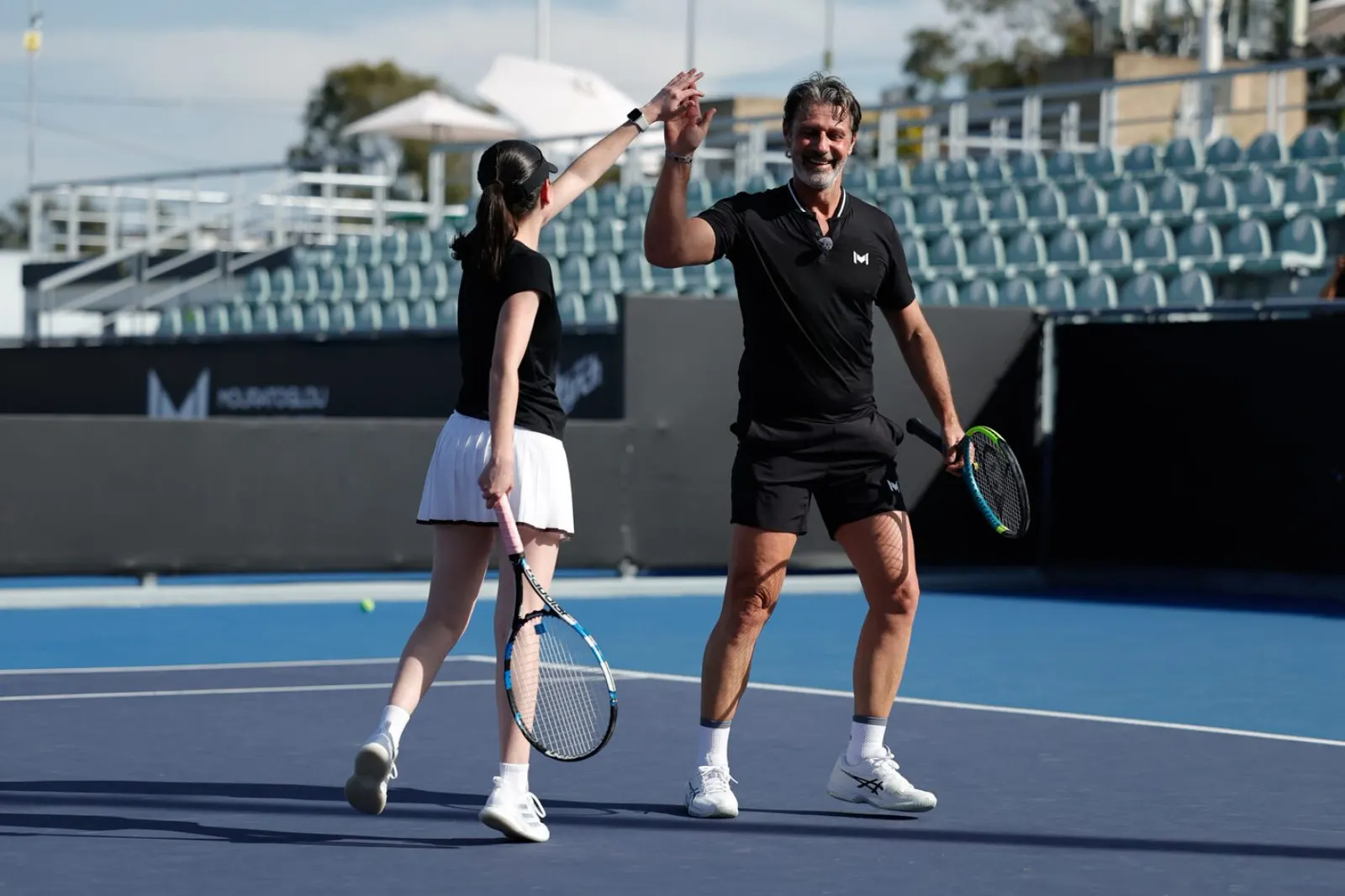 Patrick Mouratoglou chocando la mano con un jugador en la pista central de Guadalajara