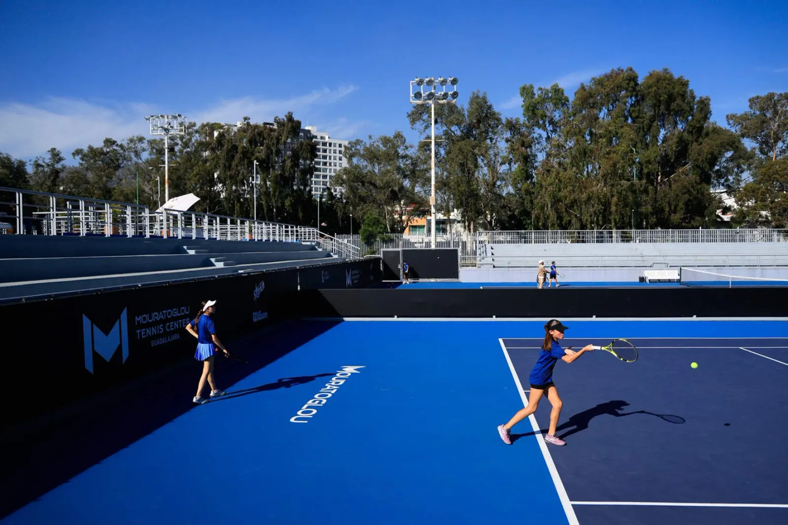 Jugadores junior entrenando en una pista azul junto al estadio del Mouratoglou Tennis Center Guadalajara