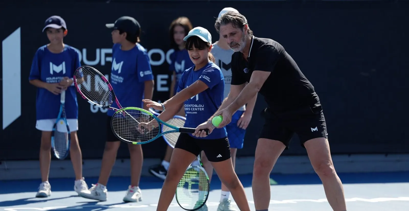 Patrick Mouratoglou mostrando una derecha a un grupo de jugadores junior en la pista en Guadalajara