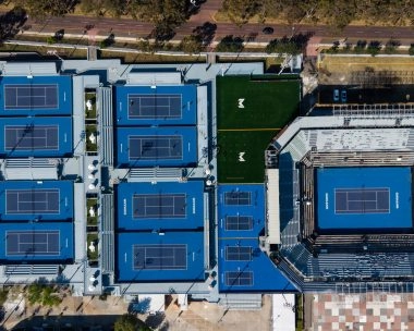Vue aérienne zénithale des courts de tennis bleus et du stade principal du Mouratoglou Tennis Center Guadalajara.