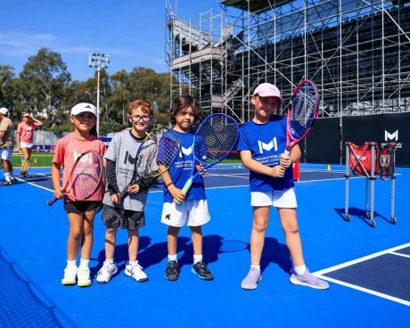 Jeunes joueurs avec leur raquette sur un court bleu du Mouratoglou Tennis Center Guadalajara.