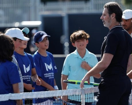 Patrick Mouratoglou s’adressant à de jeunes joueurs au filet pendant une séance de coaching au Mouratoglou Tennis Center Guadalajara.