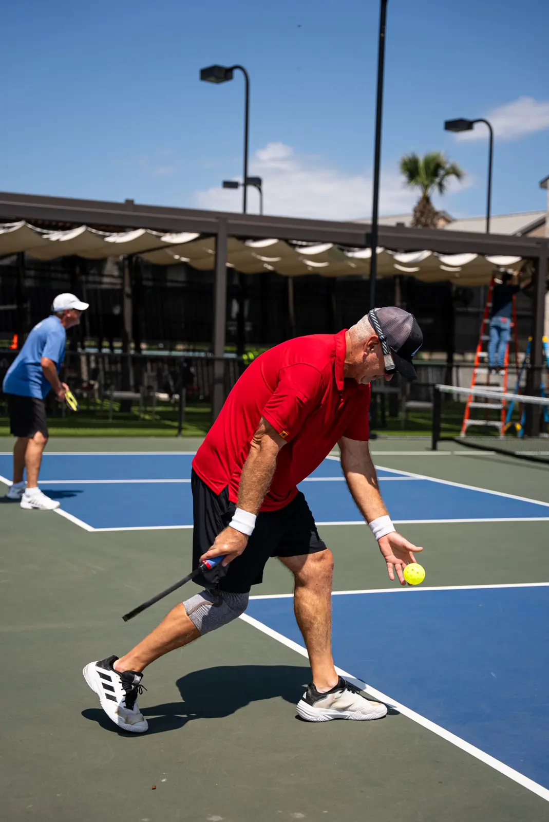 Un uomo che gioca a pickleball su un campo all’aperto