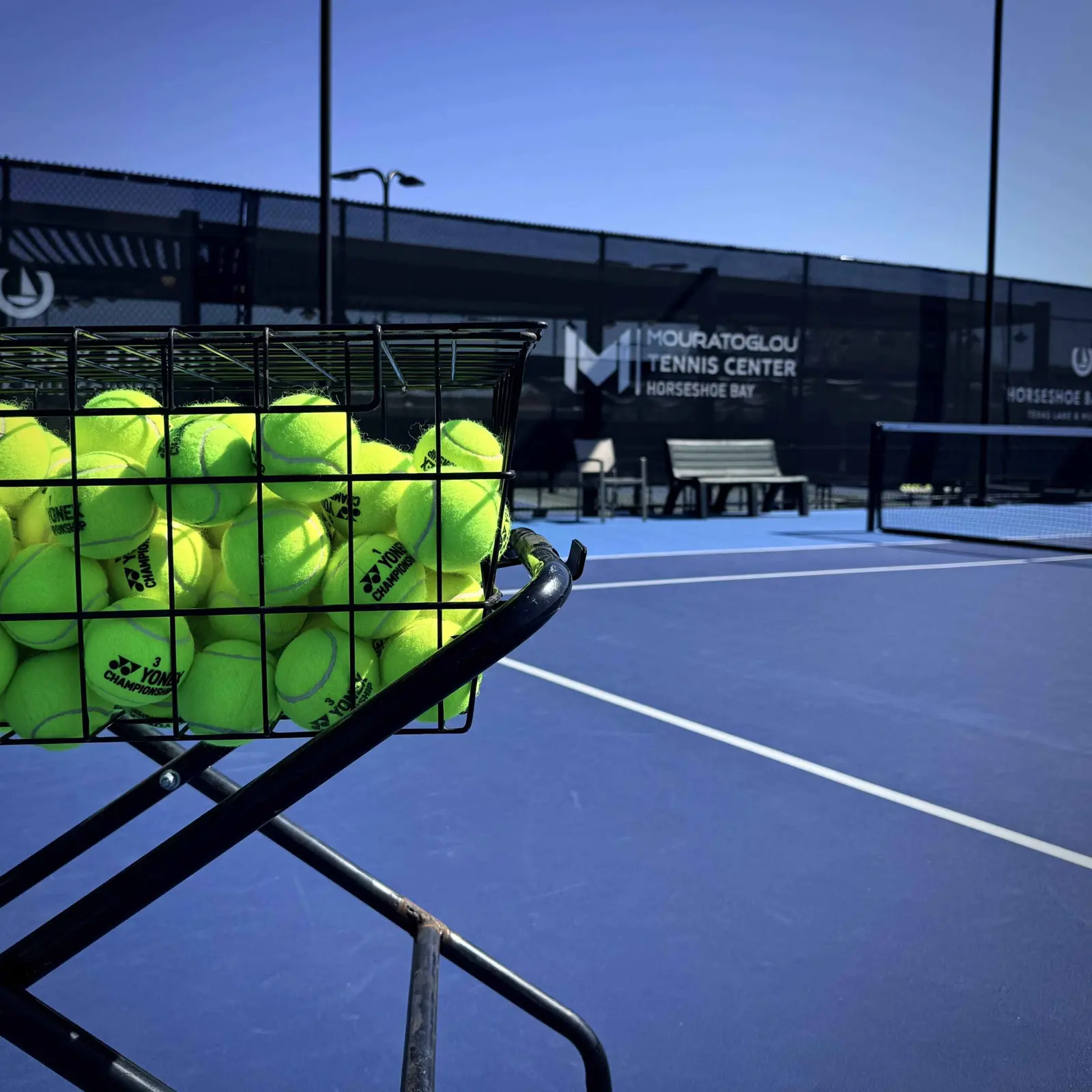 Korb mit Tennisbällen auf einem Platz