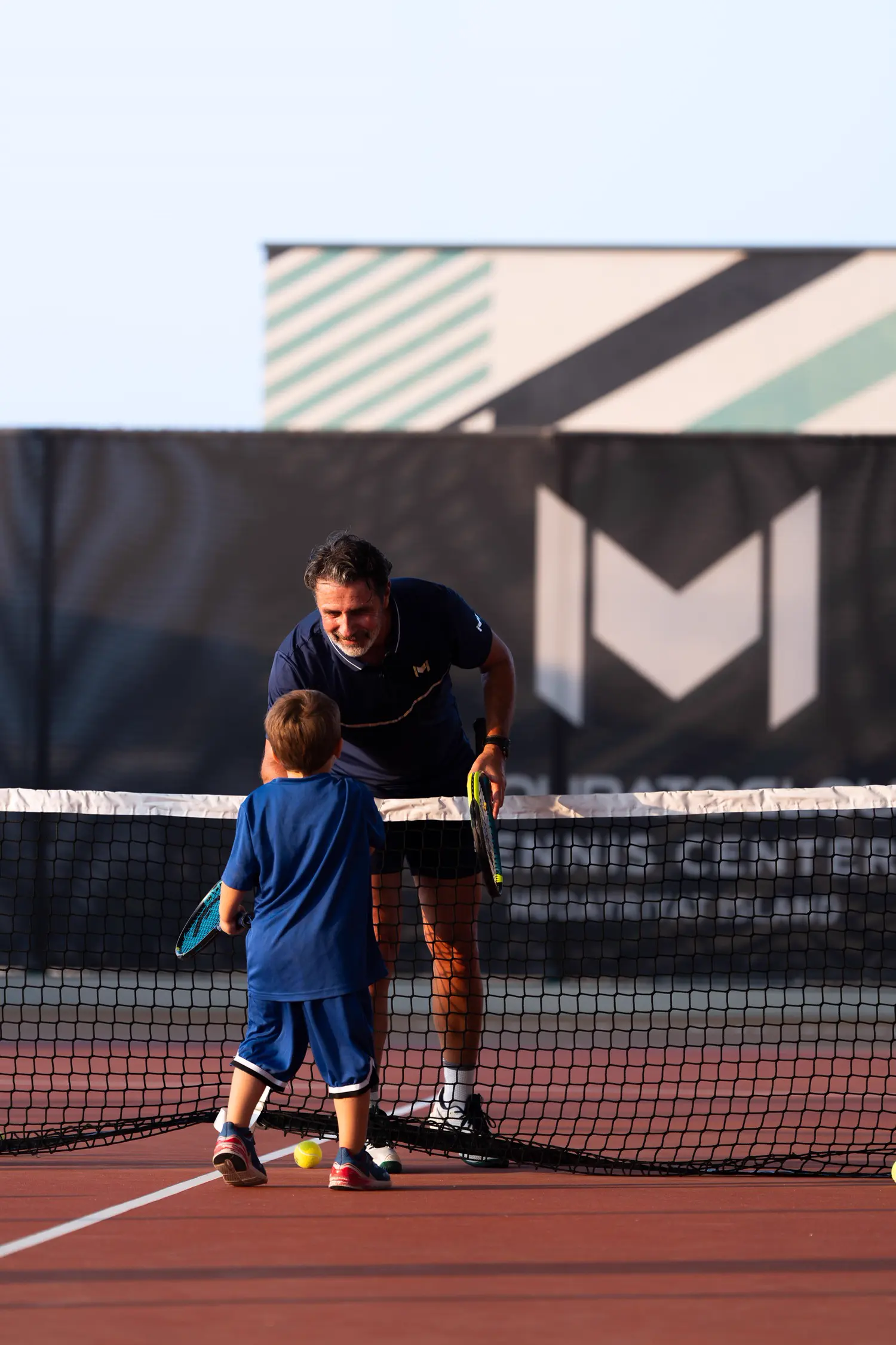 Patrick Mouratoglou allena un bambino su un campo da tennis al Mouratoglou Tennis Center Hudayriyat Island ad Abu Dhabi