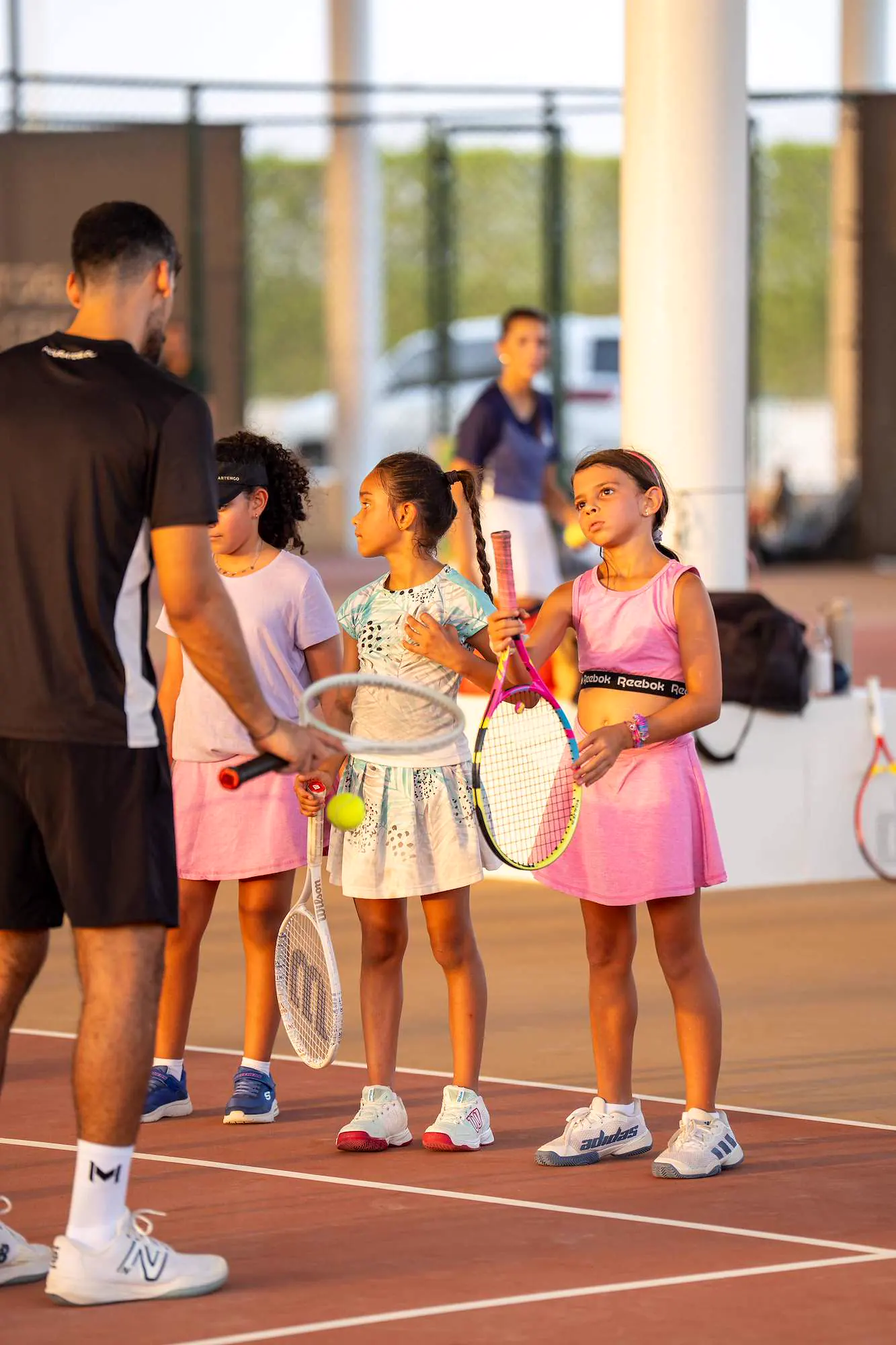 Niñas escuchando a su entrenador Mouratoglou durante una sesión junior en Abu Dabi.