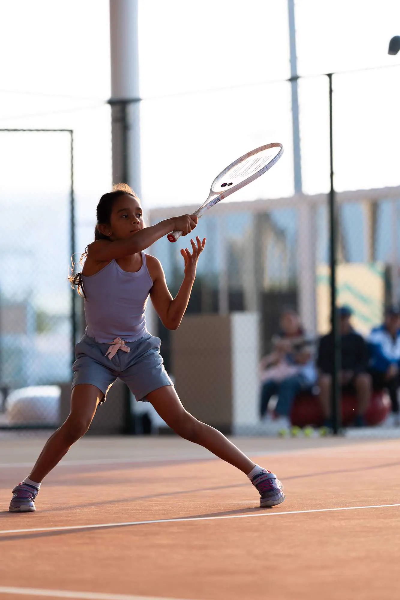 Joven jugador golpeando una derecha a pleno sol en el Mouratoglou Tennis Center Hudayriyat Island.