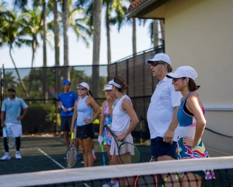 Grupo de jugadores adultos escuchando a su entrenador en la red