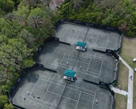 Vista aérea de pistas de tenis Har-Tru rodeadas de árboles
