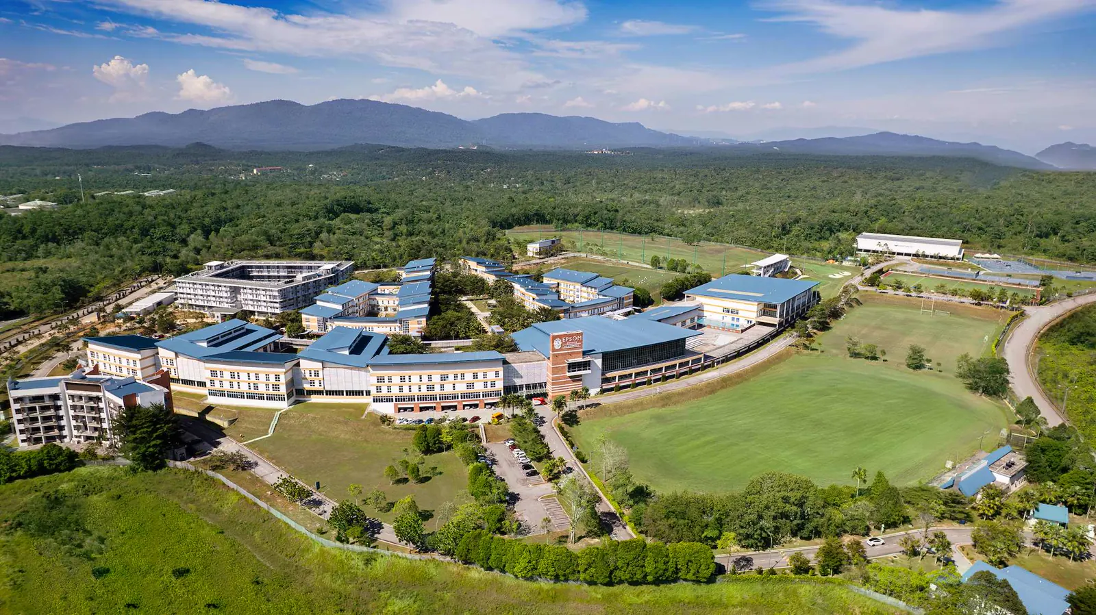 Luftaufnahme des Campus des Epsom College in Malaysia mit Bergen im Hintergrund.