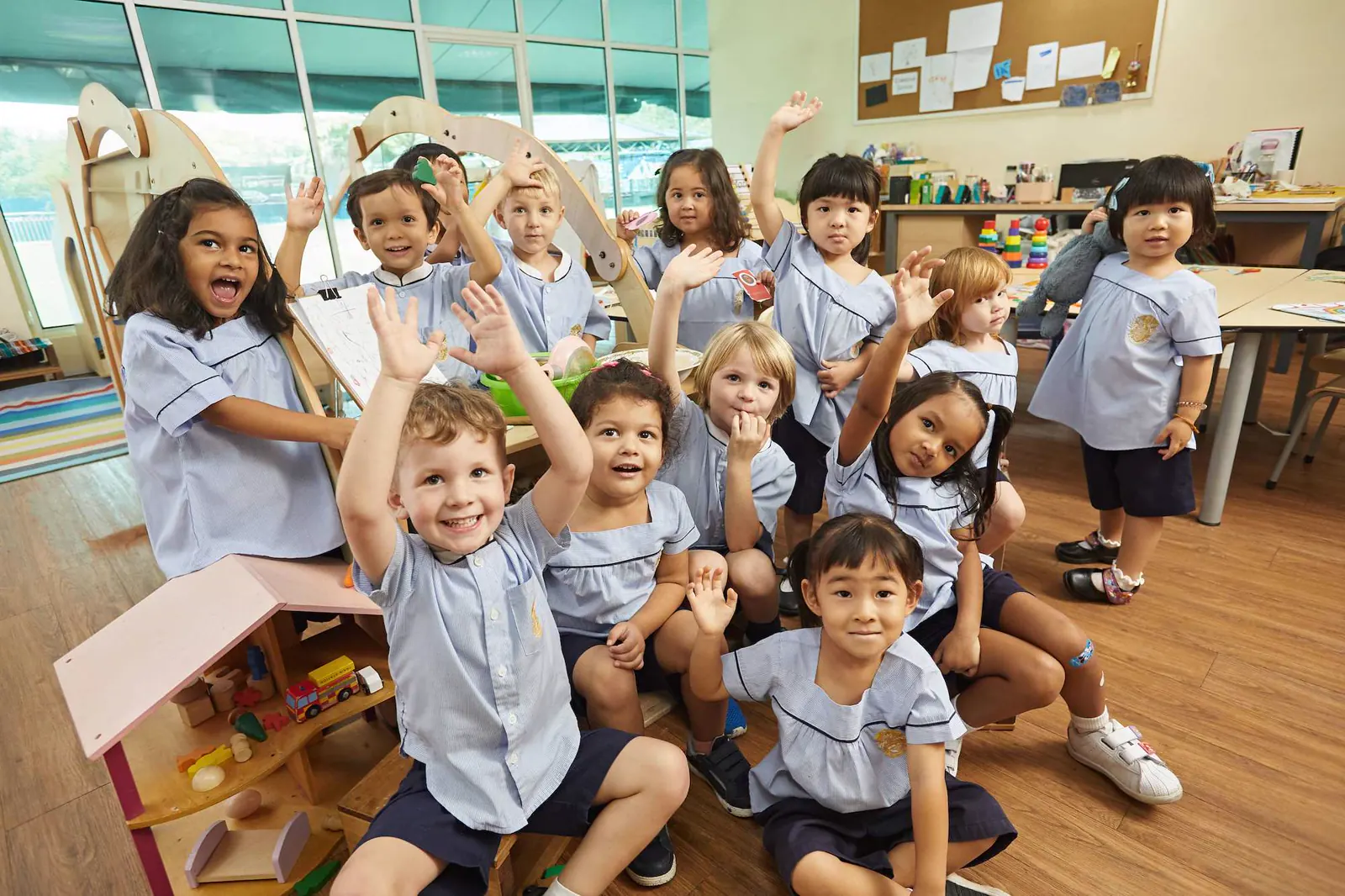 Lächelnde Grundschüler melden sich im Unterricht am Epsom College in Malaysia.