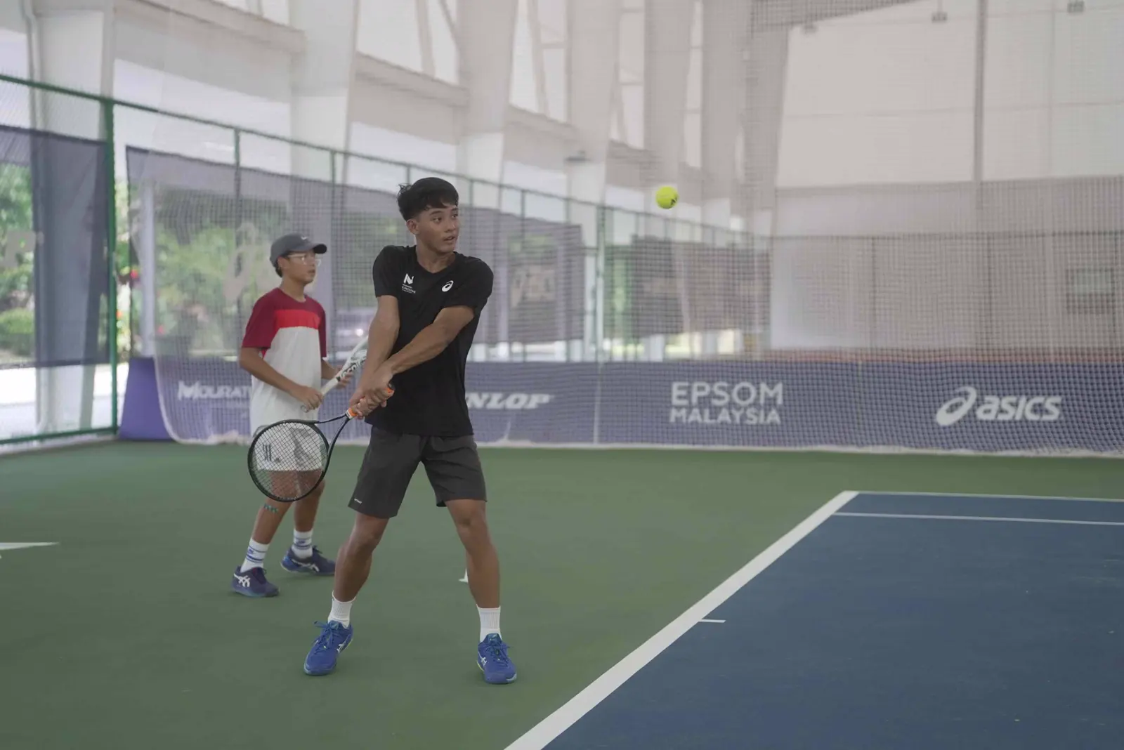 Jugadores junior de tenis practicando golpes de fondo durante un entrenamiento en la Mouratoglou Academy Malaysia