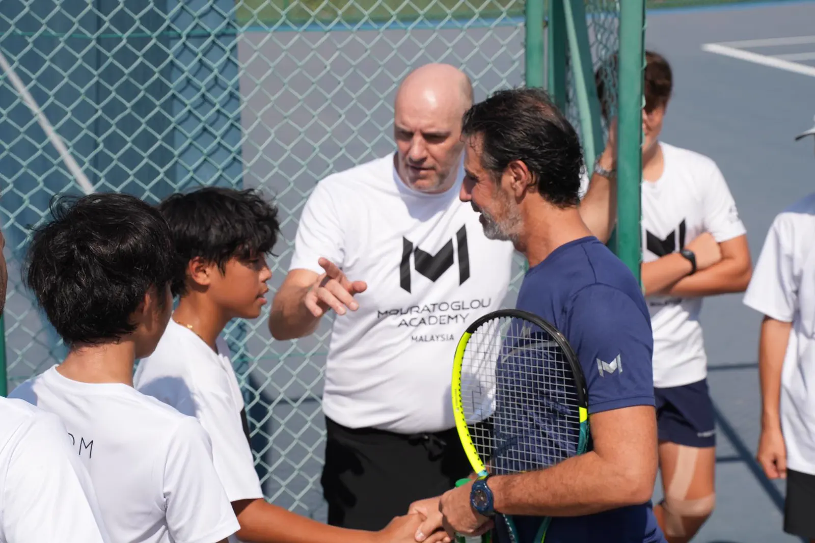 Patrick Mouratoglou hablando con alumnos en una pista de tenis de la Mouratoglou Academy Malaysia