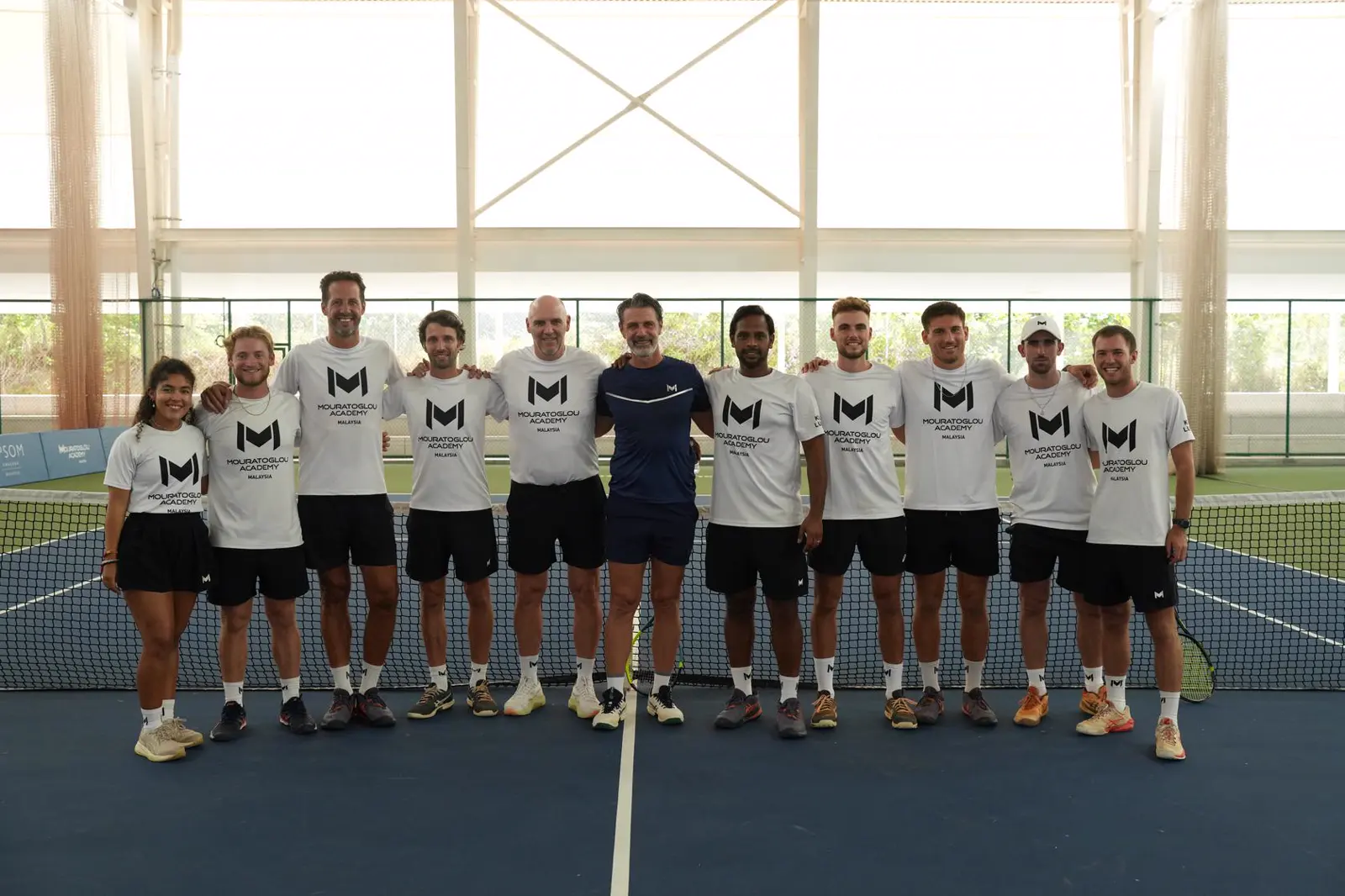 Patrick Mouratoglou con el equipo de entrenadores en una pista de tenis cubierta de la Mouratoglou Academy Malaysia