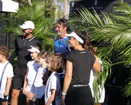 Coaches und Juniorspieler zwischen den Palmen im Mouratoglou Tennis Center Naples.