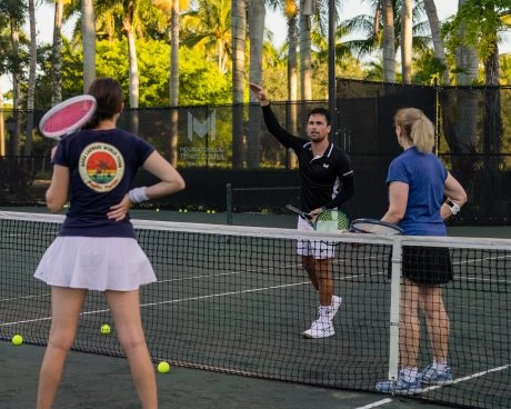 Tennistrainer gibt einer Spielergruppe Anweisungen im Mouratoglou Tennis Center Naples, Florida