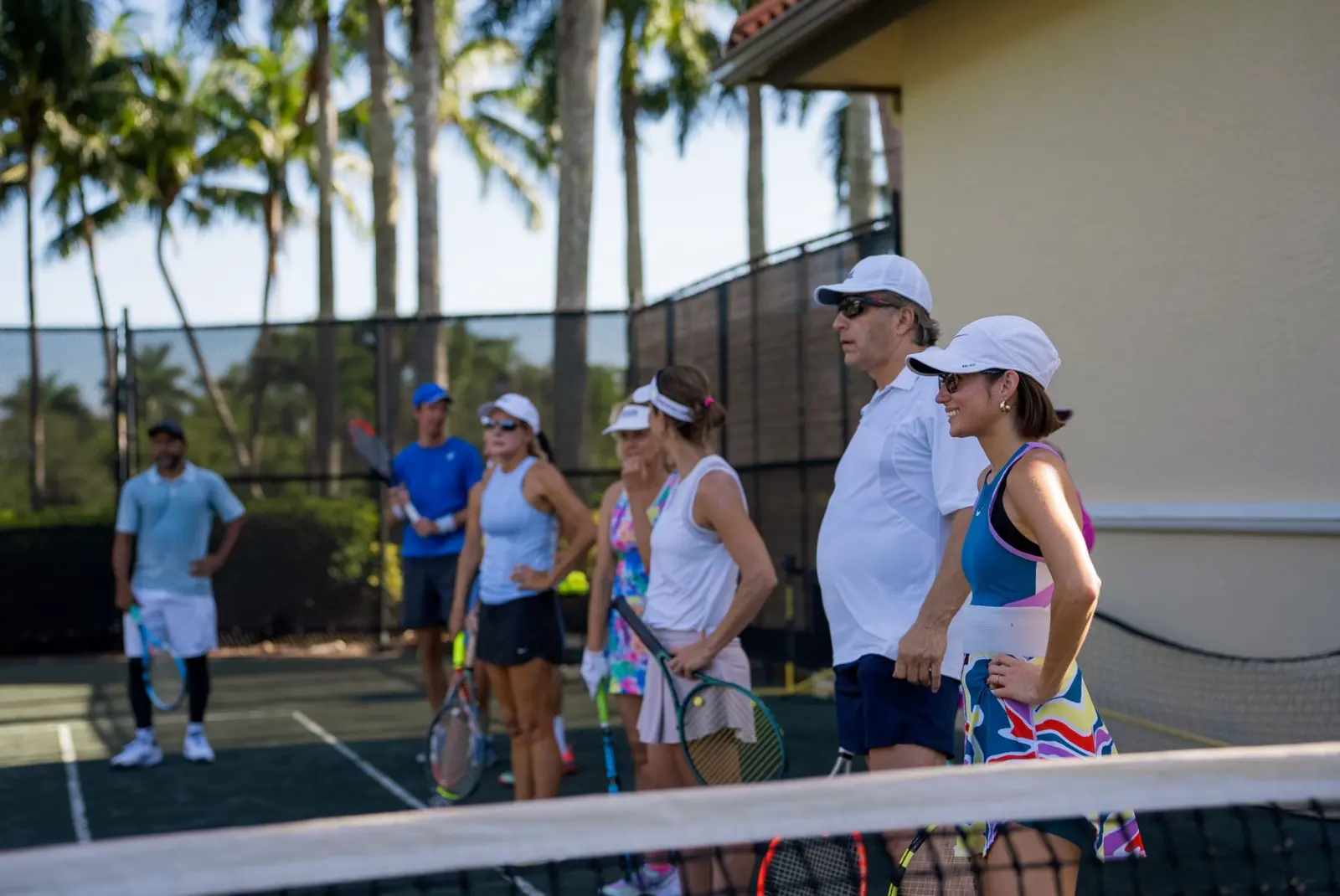 Grupo de tenistas adultos escuchando a su entrenador en Naples