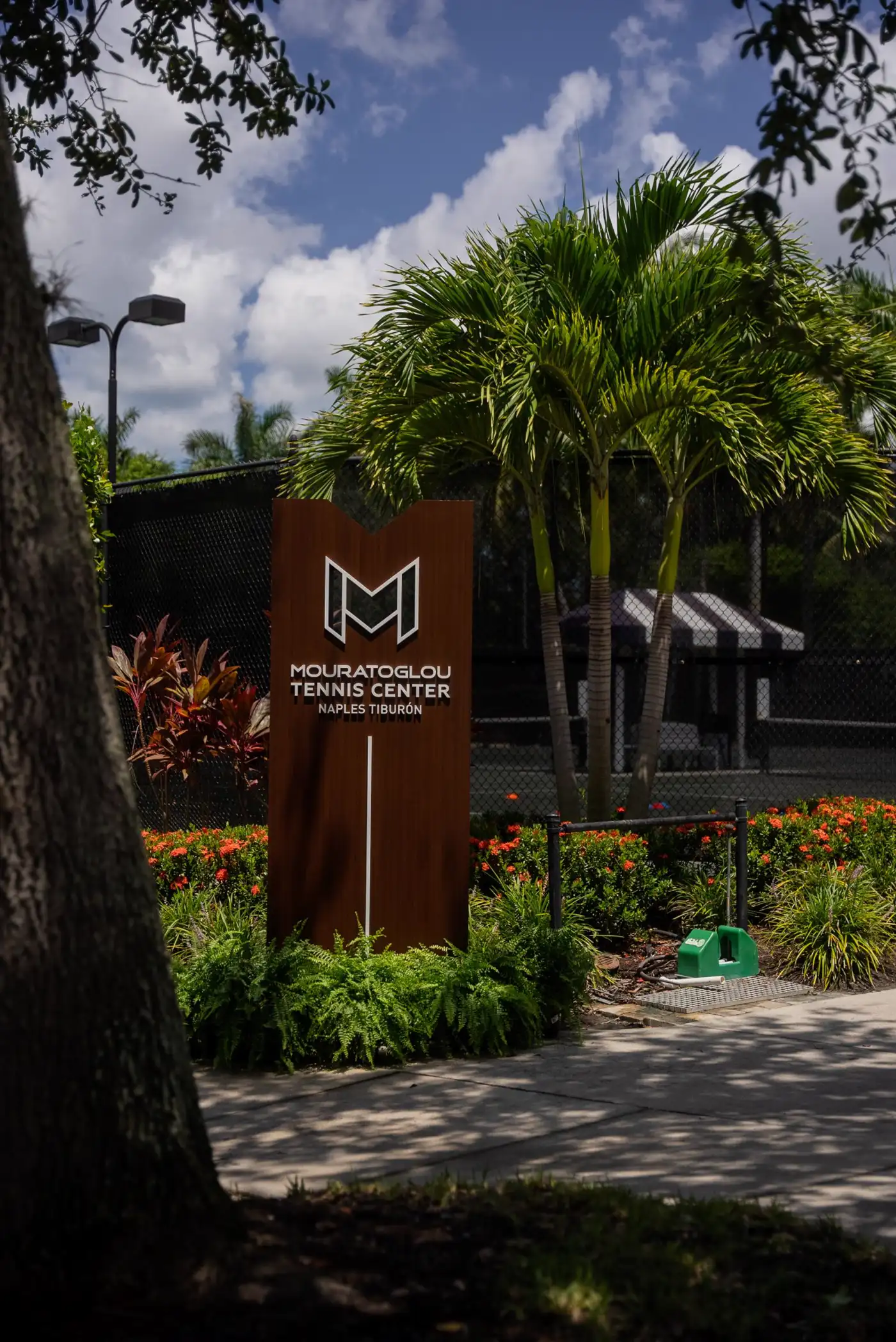 Panneau du Mouratoglou Tennis Center entouré de palmiers au Ritz-Carlton Naples, Tiburón