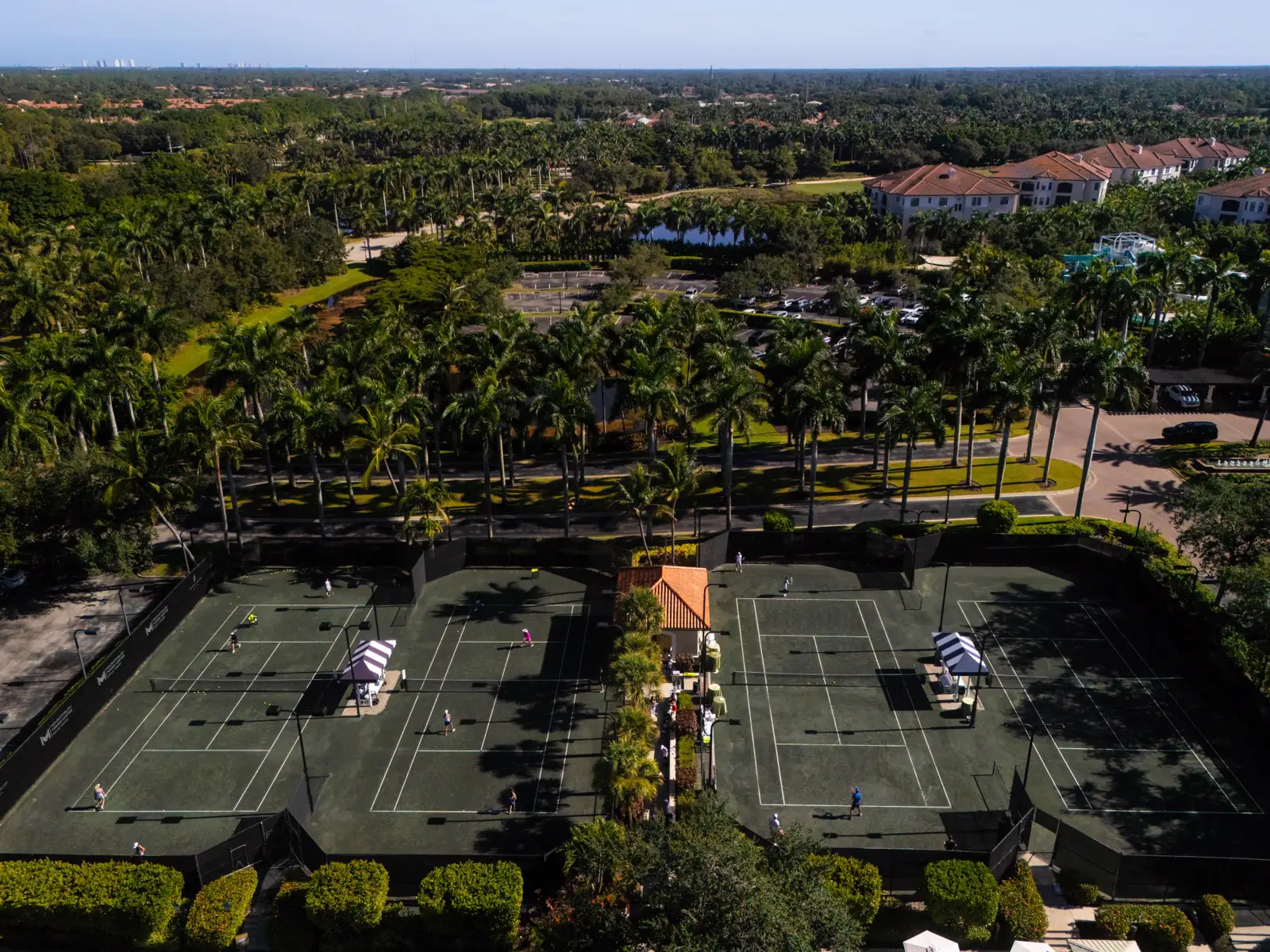 Vue aérienne des courts en terre battue avec des joueurs au Mouratoglou Tennis Center Naples