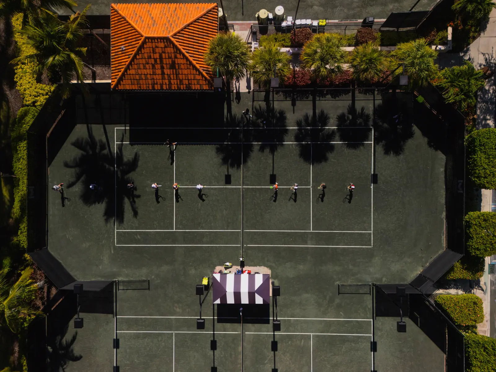 Luftaufnahme von Spielern beim Training auf den Sandplätzen des Mouratoglou Tennis Center Naples.