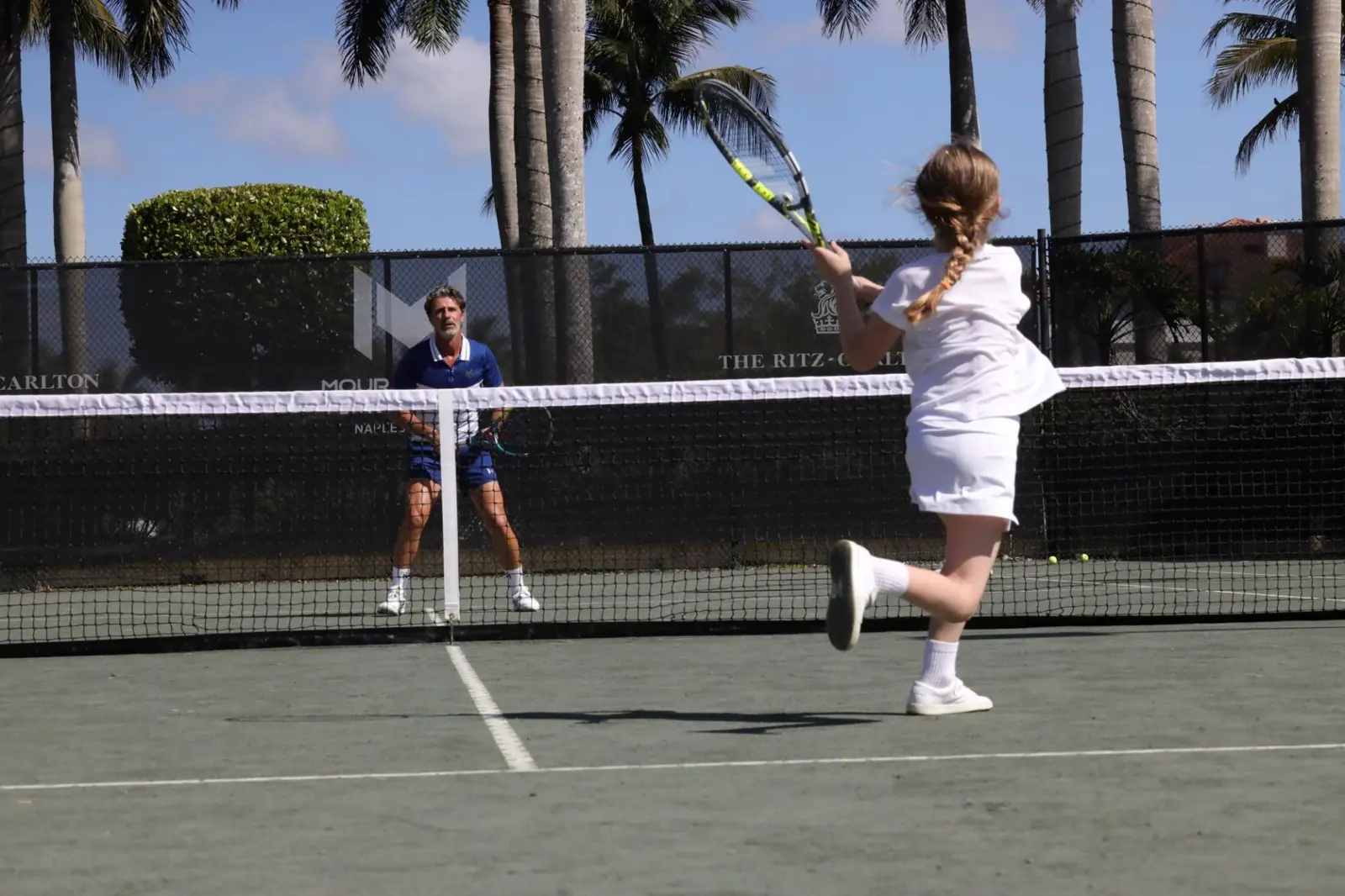 Kinder spielen während einer Junioreneinheit in Naples Tennis auf den Sandplätzen