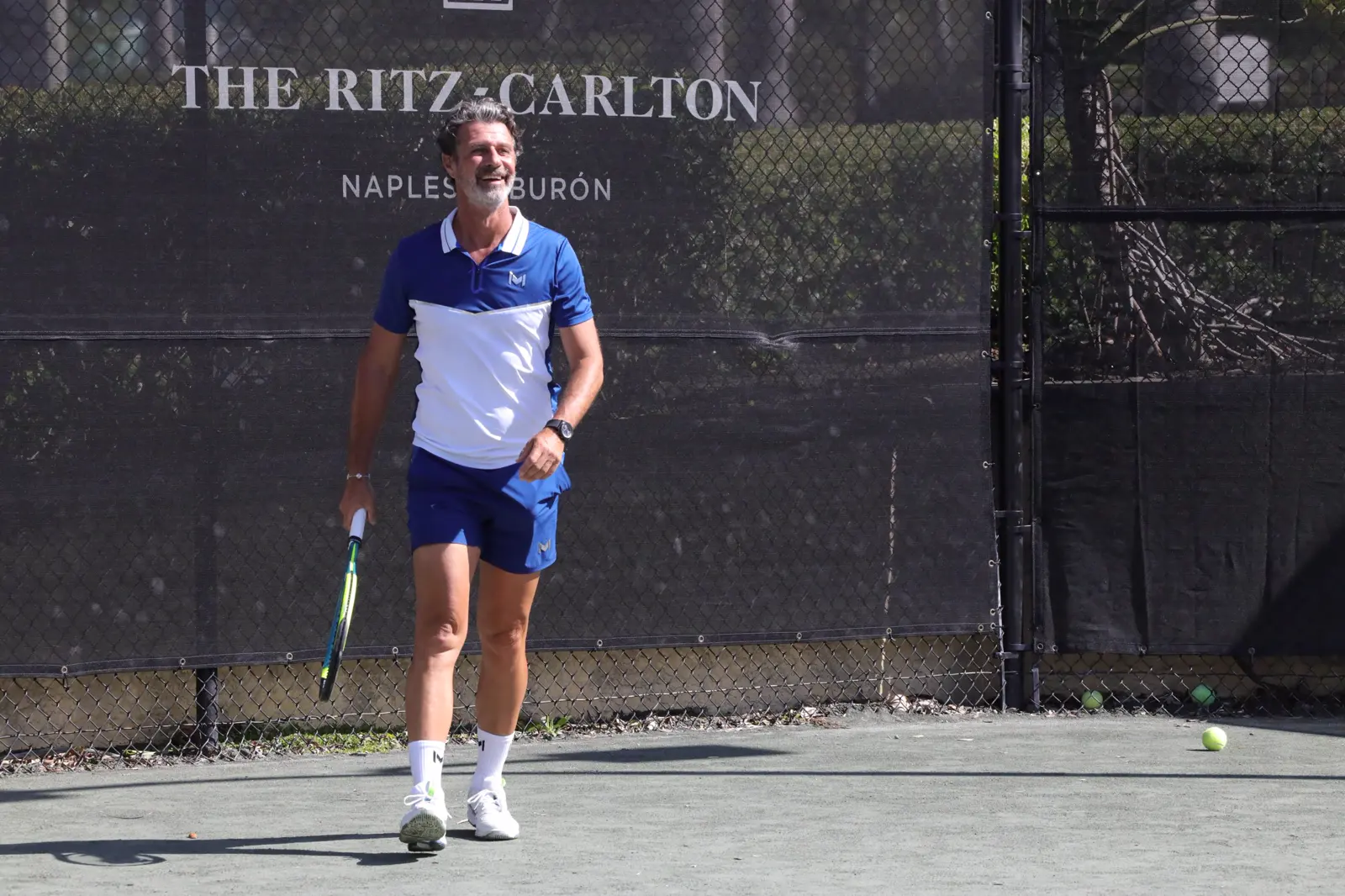 Patrick Mouratoglou sujetando una raqueta de tenis en la pista de The Ritz-Carlton Naples, Tiburón