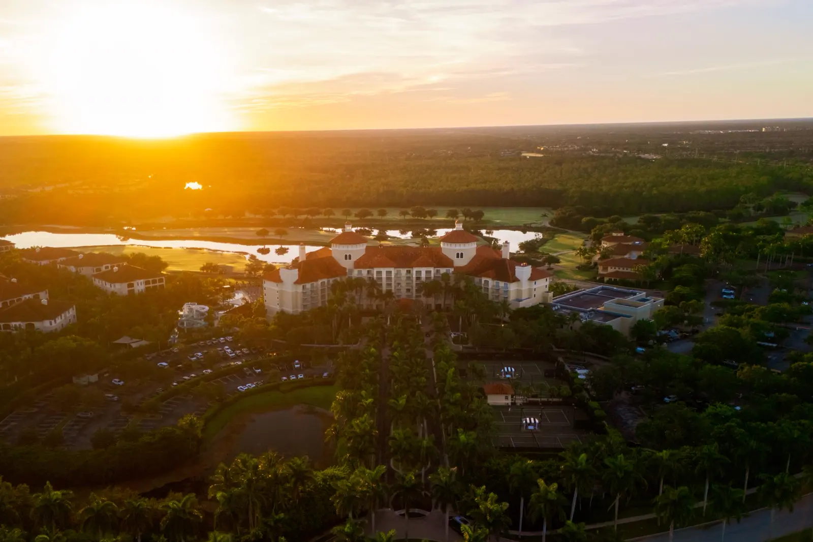 Luftaufnahme des The Ritz-Carlton Naples, Tiburón bei Sonnenuntergang.