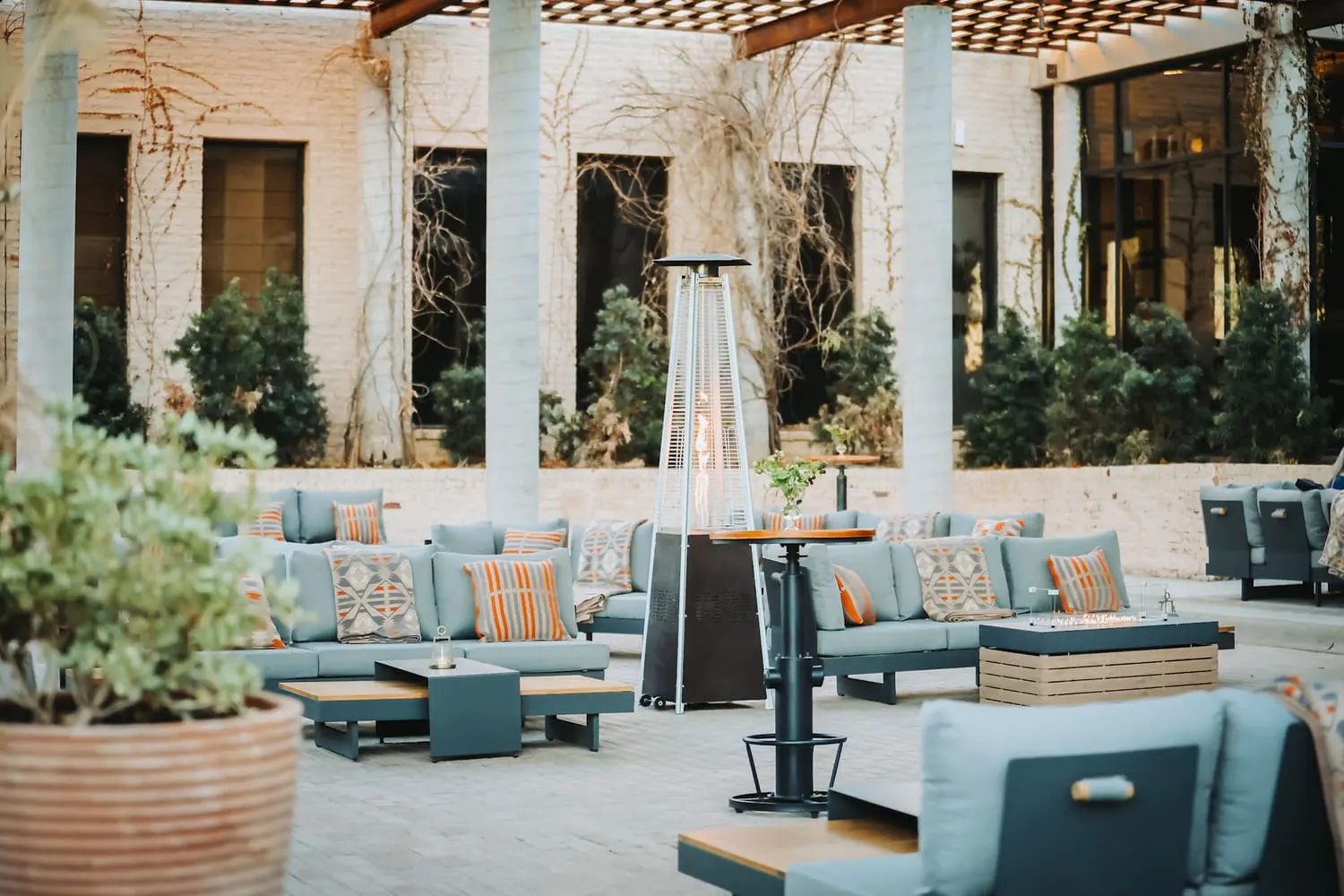 Zona lounge de la terraza con sofás y estufas exteriores en el club
