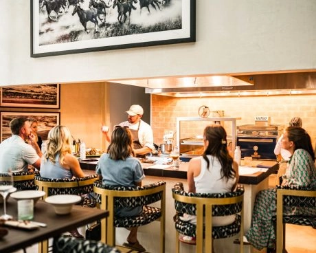 Ospiti seduti intorno a una chef’s table accanto a una cucina a vista a La Estancia, Odessa Midland.