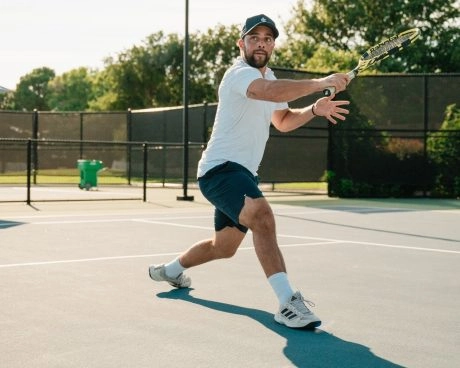 Giocatore che colpisce un dritto su un campo in cemento all’aperto al Mouratoglou Tennis Center Odessa Midland.