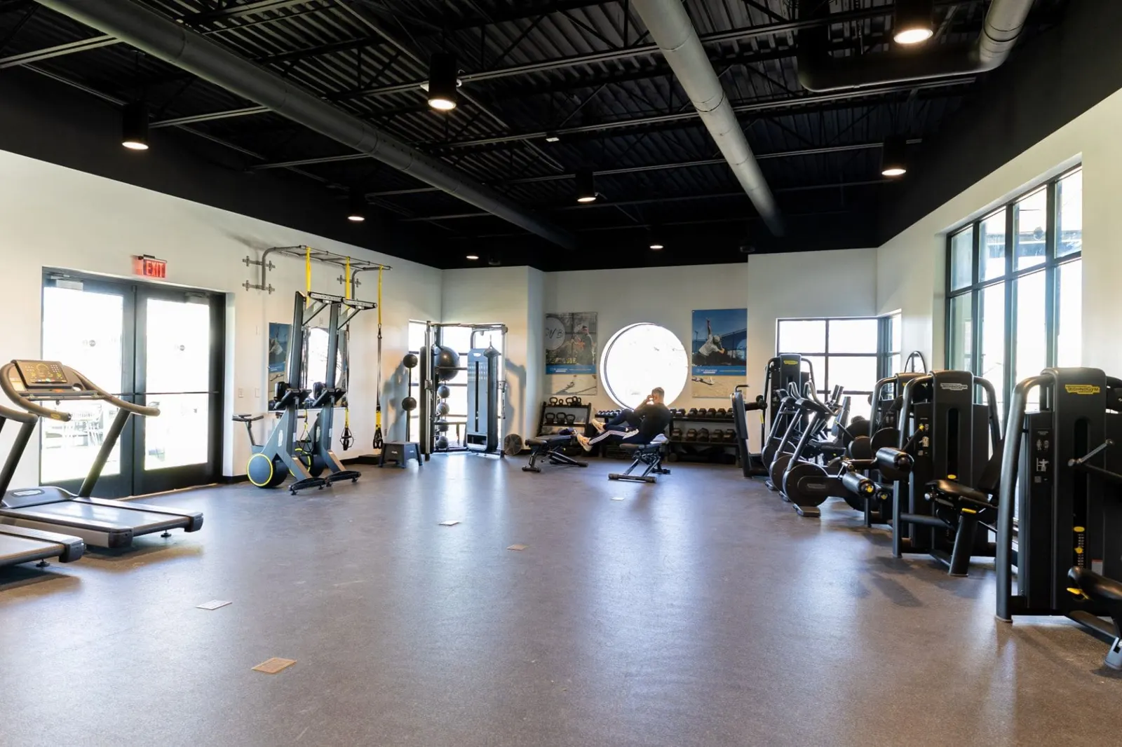 Sala de fitness luminosa con máquinas de entrenamiento y pesos libres
