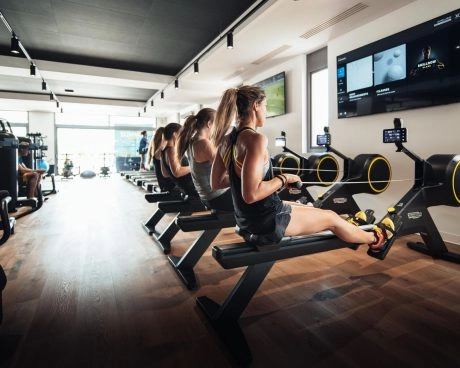 Gimnasio moderno del Hotel Mouratoglou, equipado con máquinas de entrenamiento y espacio de trabajo físico.