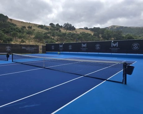 Pistas de tenis duras exteriores de la Mouratoglou Academy San Francisco, rodeadas de colinas y paisajes naturales del norte de California.